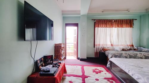 a bedroom with a bed and a tv on the wall at Family Home with Rooftop access and Mountain View in Kathmandu