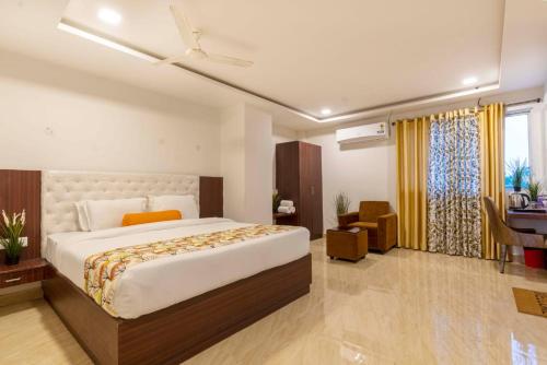 a bedroom with a large bed and a desk at Rainbow Tower Hotel Airport Road in Hyderabad
