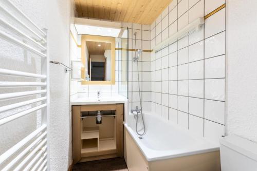 une salle de bain avec une baignoire et un lavabo dans l'établissement Résidence Les Chalets des Arolles - maeva Home - Studio 4 Personnes - Confort MAE-0024, à La Plagne Tarentaise