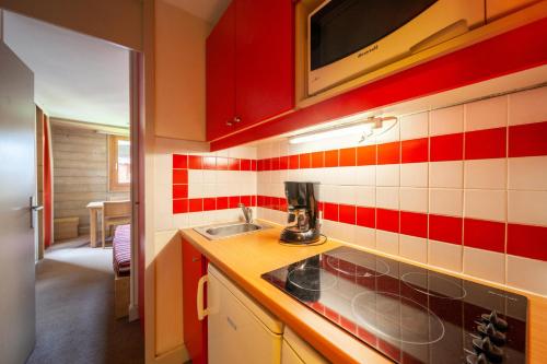- une cuisine avec un évier et du carrelage rouge et blanc dans l'établissement Résidence Plagne Lauze - maeva Home - Studio 4 Personnes - Sélection MAE-6664, à Mâcot La Plagne