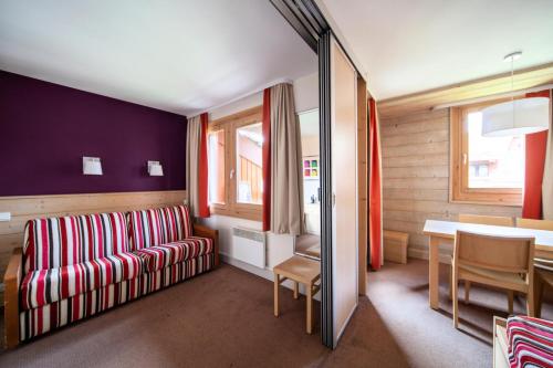 un salon avec un canapé rouge et une table dans l'établissement Résidence Plagne Lauze - maeva Home - Studio 4 Personnes - Sélection MAE-6664, à Mâcot La Plagne