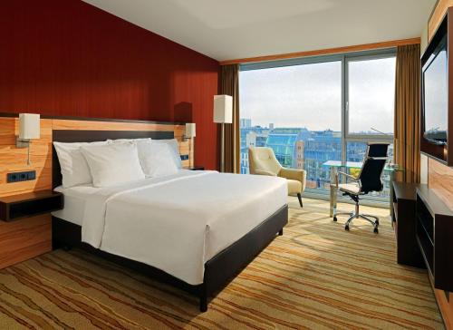 Schlafzimmer mit einem großen weißen Bett und einem Schreibtisch in der Unterkunft Courtyard by Marriott Duesseldorf Hafen in Düsseldorf