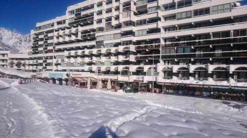 a large building with snow on the ground in front of it at Résidence Podium - Studio pour 3 Personnes 974 in Les Prés