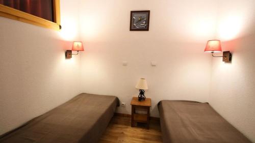 une chambre avec deux lits et une table avec une lampe dans l'établissement Résidence Dame Blanche - DBA104 - APPT 1 CHAMBRE + CABINE - BALCON - 6 PERSONNES MAE-2224, à Narreyroux