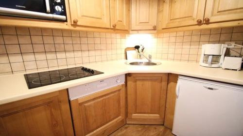 une cuisine avec un évier et une cuisinière four supérieur dans l'établissement Résidence Dame Blanche - 2 Pièces pour 4 Personnes MAE-2254, à Narreyroux