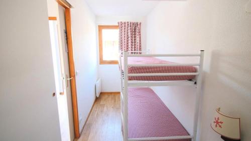 une petite chambre avec deux lits superposés et une fenêtre dans l'établissement Résidence Parc Aux Etoiles - CH28PAE - CHALET TRIPLEX T5 - TERRASSE - 7 PERS MAE-2104, à Narreyroux