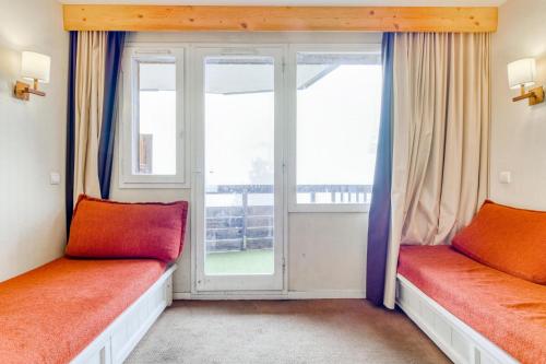 two beds in a room with a window at Résidence Quartier Falaise - maeva Home - Appartement 2 Pièces 5 Personnes - Sélection MAE-6534 in Avoriaz