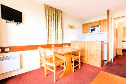 une salle à manger avec une table et une cuisine dans l'établissement Résidences quartier Charmettoger - maeva Home - Appartement 2 Pièces 5 Personnes - Budget MAE-9914, à Arc 1800