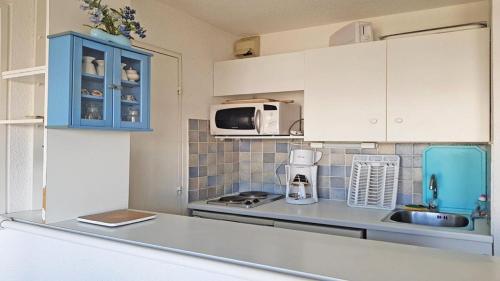 une cuisine avec des armoires blanches et un comptoir dans l'établissement Résidence Pendine 2 - P2302 - Appt T2 - 5 PERSONNES - Pied des pistes MAE-1994, à Les Prés