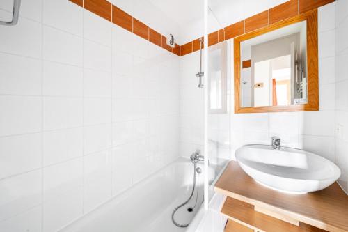 a white bathroom with a sink and a mirror at Résidence Plagne Lauze - maeva Home - Appartement 2 Pièces 5 Personnes - P 144 in Mâcot La Plagne