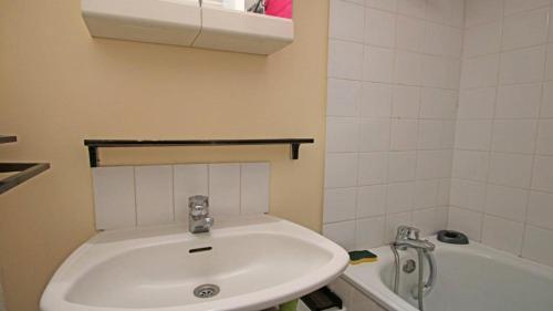 Un baño con un lavabo blanco y una bañera. en Résidence Portillo - POR206 - APPT T2 - 5 PERSONNES - VUE PISTES - CENTRE STATION MAE-2294, en Les Prés
