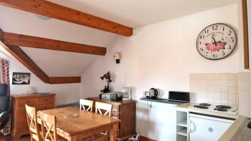 une cuisine avec une table et une horloge au mur dans l'établissement Résidence Parc Aux Etoiles - A204PAE - APPARTEMENT 1 CHAMBRE, BALCON MAE-2324, à Narreyroux