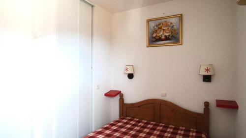 une chambre avec un lit et un tableau au mur dans l'établissement Résidence Parc Aux Etoiles - A204PAE - APPARTEMENT 1 CHAMBRE, BALCON MAE-2324, à Narreyroux
