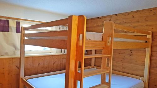 two bunk beds in a room with a window at Résidence Podium - Studio pour 5 Personnes 384 in Les Prés