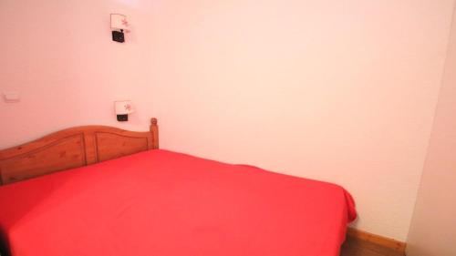 une chambre avec un lit avec une couverture rouge dans l'établissement Résidence Parc Aux Etoiles - B202PAE - APPARTEMENT 1 CHAMBRE, BALCON MAE-2444, à Narreyroux