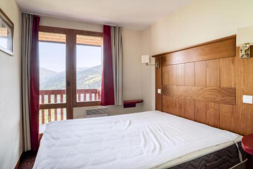 une chambre avec un grand lit et une fenêtre dans l'établissement Résidence La Marelle et Le Rami - maeva Home - Appartement 2 Pièces 7 Personnes - Sélection MAE-7164, à La Plagne Tarentaise