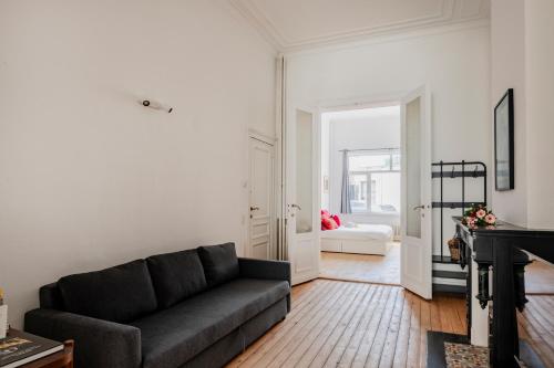 uma sala de estar com um sofá e um piano em Brussels Benit Ixelles Residence em Bruxelas