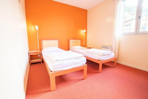 deux lits dans une chambre aux murs orange dans l'établissement Résidence Le Pra - LE PRA - PR13CO MAE-3057, à Villarodin-Bourget