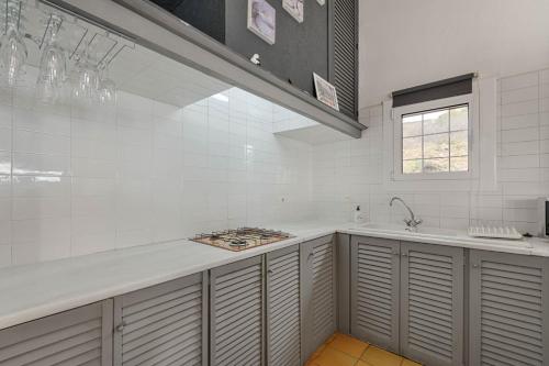 eine weiße Küche mit einer Theke und einem Waschbecken in der Unterkunft El paraíso de Cadaqués IMMO365 in Cadaqués