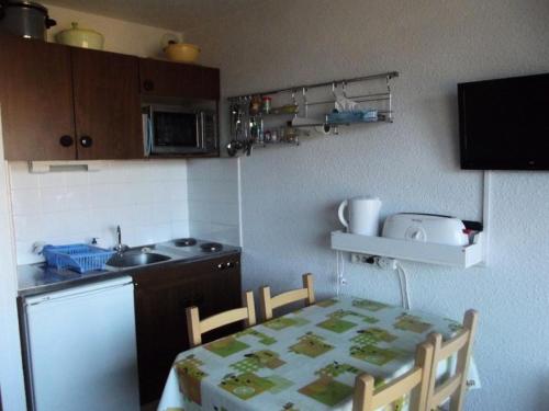 une petite cuisine avec une table, des chaises et un évier dans l'établissement Résidence St Moritz - STM304 - STUDIO 2/3 PERSONNES EN CENTRE STATION MAE-2564, à Les Prés