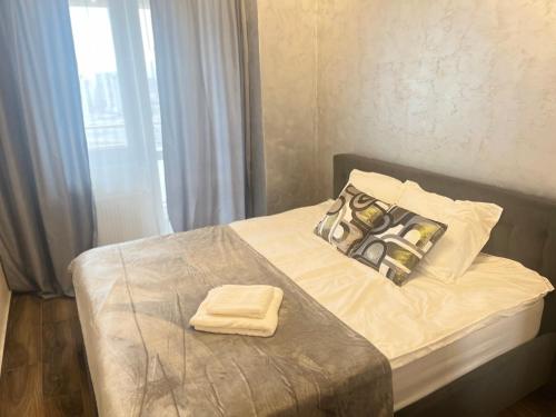 a bed with two towels sitting on top of it at Apartments Lux Palas in Iaşi