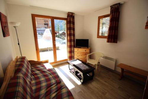 une chambre avec un lit, une table et une télévision dans l'établissement Chalet Arrondaz C - CHALET ARRONDAZ - CHAARC2 MAE-3073, à Modane