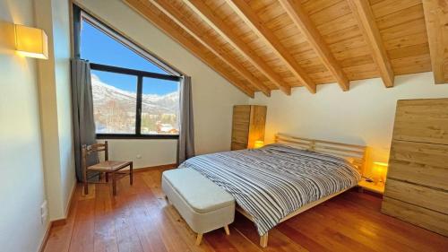 a bedroom with a bed and a large window at Chalet - Chalets pour 12 Personnes 644 in Les Prés