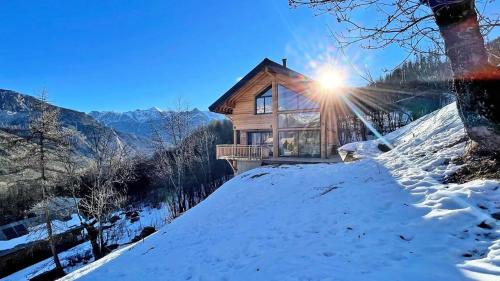 a log cabin in the snow with the sun shining at Chalet - Superbe Chalet 12 pers MAE-2644 in Les Prés