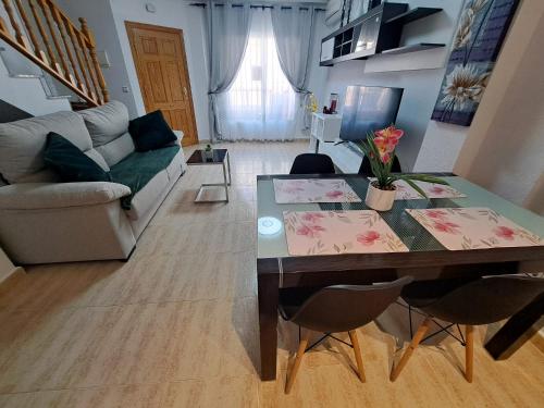 a living room with a table and a couch at Nice 3 bedroom Duplex Cabo Roig in Orihuela Costa