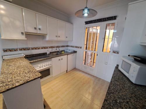 a kitchen with white cabinets and a counter top at Nice 3 bedroom Duplex Cabo Roig in Orihuela Costa