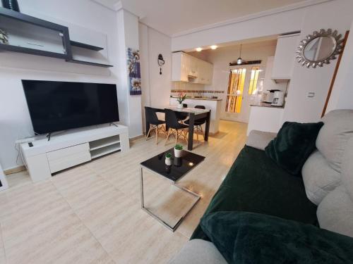 een woonkamer met een bank en een tafel bij Nice 3 bedroom Duplex Cabo Roig in Orihuela