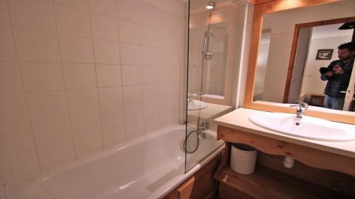 un homme prenant une photo d'une salle de bains avec lavabo et douche dans l'établissement Résidence Dame Blanche - DBA307 - APPT 1 CHAMBRE + CABINE - BALCON - 6 PERSONNES MAE-3084, à Narreyroux