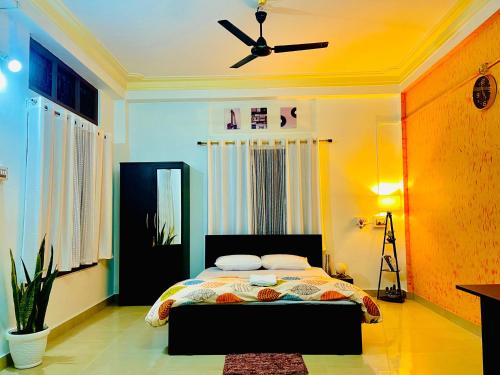 sypialnia z łóżkiem i wentylatorem sufitowym w obiekcie Aurora Inn w mieście Sibsāgar