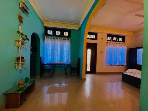 salon ze stołem i niebieskimi ścianami w obiekcie Aurora Inn w mieście Sibsāgar