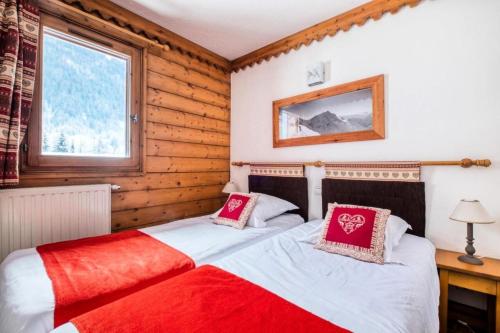 une chambre avec deux lits et une fenêtre dans l'établissement Résidence La Ginabelle - maeva Home - Appartement 3 pièces 6 personnes avec parking - Prestige MAE-8604, à Chamonix-Mont-Blanc
