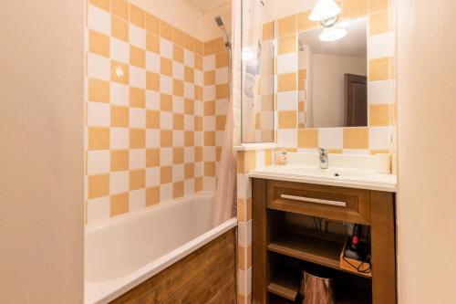 une salle de bain avec un lavabo, une baignoire et un miroir dans l'établissement Résidence L'Albane - maeva Home - Appartement chaleureux 2 pièces 5 personnes - Prestige - super Home MAE-8994, à Vars