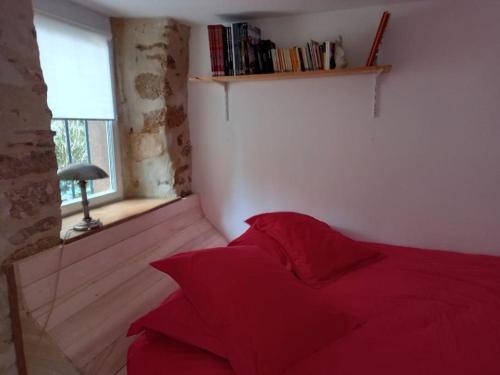 a red bed in a room with a window at La Loupière in Avallon
