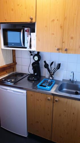 une cuisine avec un évier et un micro-ondes dans l'établissement Résidence Thabor A - THABOR A - THAA25 MAE-3092, à Modane
