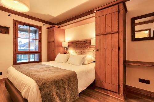 une chambre avec un grand lit et une fenêtre dans l'établissement Résidence Les Arcs 1950 Le Village - maeva Home - Appartement 3 pièces 6 personnes - Prestige MAE-5494, à Bourg-Saint-Maurice