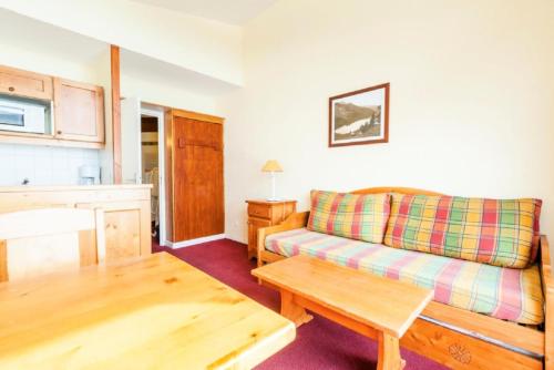 un salon avec un canapé et une table dans l'établissement Résidences quartier Charmettoger - maeva Home - 2 Pièces 5 Personnes - Budget MAE-1114, à Arc 1800