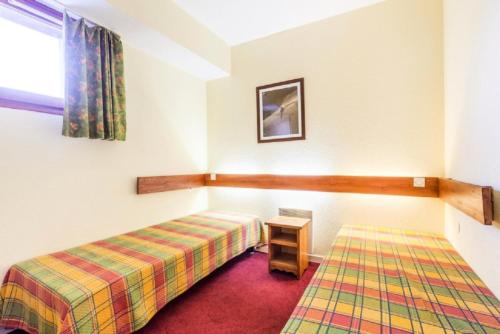 une pièce avec un lit et une table dedans dans l'établissement Résidences quartier Charmettoger - maeva Home - 2 Pièces 5 Personnes - Budget MAE-1114, à Arc 1800