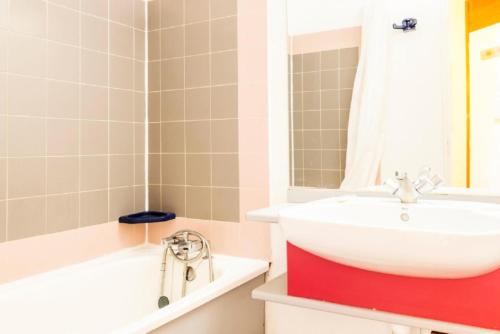 une salle de bain avec un lavabo blanc et une baignoire dans l'établissement Résidences quartier Charmettoger - maeva Home - 2 Pièces 5 Personnes - Budget MAE-1114, à Arc 1800