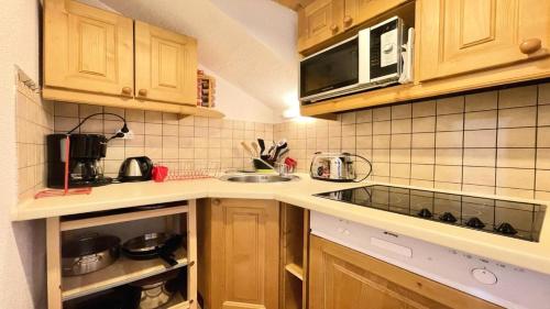 une cuisine avec un évier et un micro-ondes dans l'établissement Résidence Dame Blanche - DBA402 - APPT 2 CHAMBRES - BALCON - 6 PERSONNES - Secteur 1800 MAE-7584, à Narreyroux