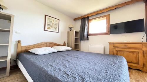 une chambre avec un lit bleu et une télévision dans l'établissement Résidence Dame Blanche - DBA204 - APPT 1 CHAMBRE + CABINE - BALCON - 6 PERSONNES MAE-7574, à Narreyroux