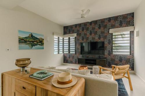 a living room with a couch and a table at Tamarin Sunset Beach II in Tamarin