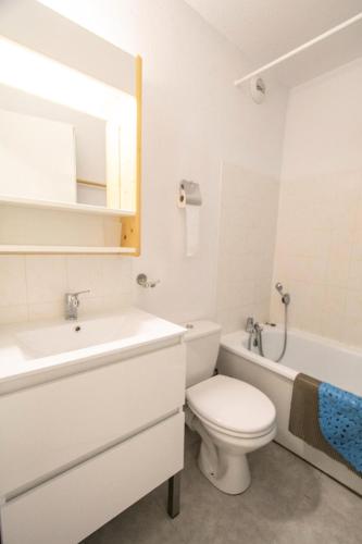 La salle de bains blanche est pourvue de toilettes, d'un lavabo et d'une baignoire. dans l'établissement Résidence Grand Argentier - GRAND ARGENTIER - GA08 MAE-3097, à Modane
