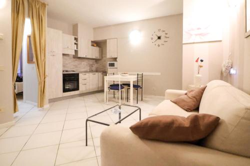 een woonkamer met een bank en een tafel en een keuken bij Casa San Giovanni in Desenzano del Garda