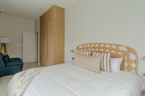 a bedroom with a large white bed with a wooden headboard at Tamarin Sunset Beach II in Tamarin