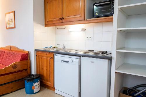 une petite cuisine avec un évier et un réfrigérateur dans l'établissement Chalet D'arrondaz H - CHALET ARRONDAZ - CHAARH21 MAE-3103, à Modane