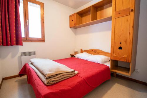 une chambre avec un lit avec une couverture rouge dessus dans l'établissement Chalet D'arrondaz H - CHALET ARRONDAZ - CHAARH21 MAE-3103, à Modane